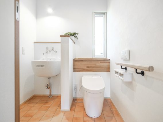 新築住宅の綺麗なスロップシンク付きのトイレ
