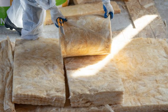 Professional foreman installing thermal insulation rock wool under the roof